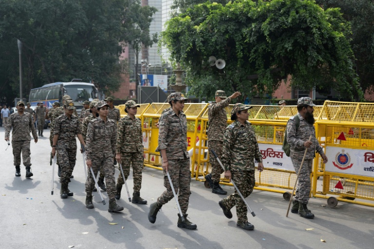 Les membres des forces de sécurité arrivent pour prendre leur poste à un point de contrôle temporaire à New Delhi, le 11 octobre 2026