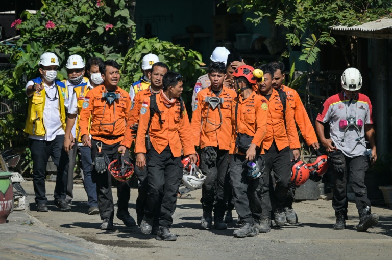 Des membres des équipes de secours quittent le site de l'effondrement de l'internat islamique Al Khoziny à Sidoarjo, dans l'est de Java, le 6 octobre 2025 en Indonésie