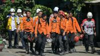 Des membres des équipes de secours quittent le site de l'effondrement de l'internat islamique Al Khoziny à Sidoarjo, dans l'est de Java, le 6 octobre 2025 en Indonésie