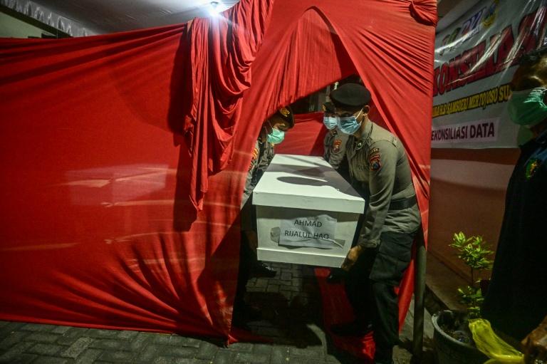 Des policiers transportent le cercueil d'un étudiant, le 5 octobre 2025 à l'hôpital Bhayangkara de Surabaya, tué dans l'effondrement d'un bâtiment de l'internat islamique Al Khoziny à Sidoarjo, en Indonésie