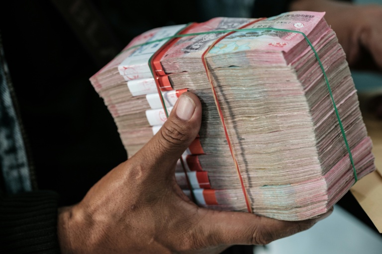 Un homme reçoit une liasse de billets de roupies dans un bureau de change à Jakarta en Indonésie le 4 juin 2026