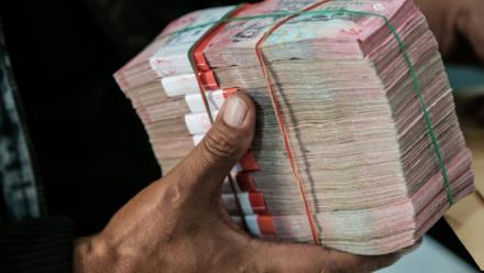 Un homme reçoit une liasse de billets de roupies dans un bureau de change à Jakarta en Indonésie le 4 juin 2026