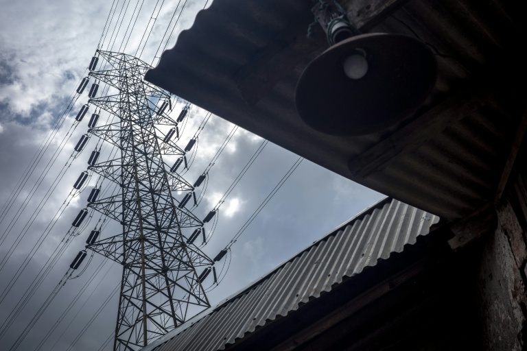 Un pylône à haute tension au-dessus de la maison d'un pêcheur, près de la centrale de Cirebon, en Indonésie, le 29 janvier 2026