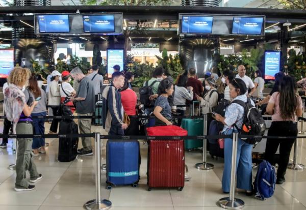 Des passagers bloqués à l'aéroport Soekarno-Hatta de Tangerang font la queue pour demander le remboursement de leurs billets après l'annulation de vols réguliers due à l'éruption du volcan Anak Krakatoa, le 6 septembre 2026 en Indonésie
