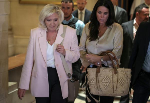 Marine Le Pen, présidente du groupe parlementaire du Rassemblement national (g), accompagnée de la députée européenne Catherine Griset (d), quitte la cour d'appel de Paris le 7 juillet 2026, après le prononcé de l'arrêt en appel pour détournement de fonds publics européens dans l'affaire des emplois présumés fictifs au Parlement européen