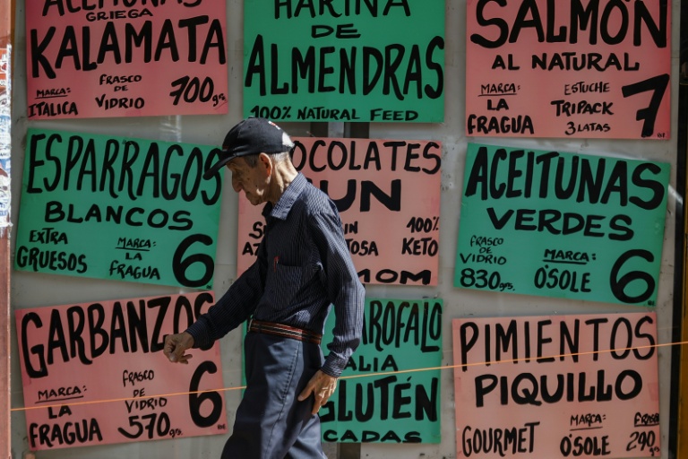  Un homme passe devant des panneaux affichant les prix en dollars américains à Caracas, au Venezuela, le 2 juin 2025