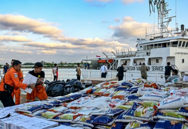 Des membres des sercives de secours et de recherche indonésiens chargent des denrées collectées pour venir en aide aux victimes des inondations à Banda Aceh, le 1er décembre 2025, en Indonésie