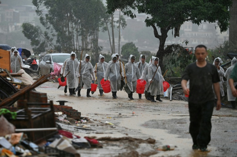 Des sécouristes participent aux opérations de nettoyage dans le village de Liulan, inondé après l'effondrement, du réservoir de Liulan, à Hengzhou, dans la région chinoise du Guangxi, le 8 juillet 2026