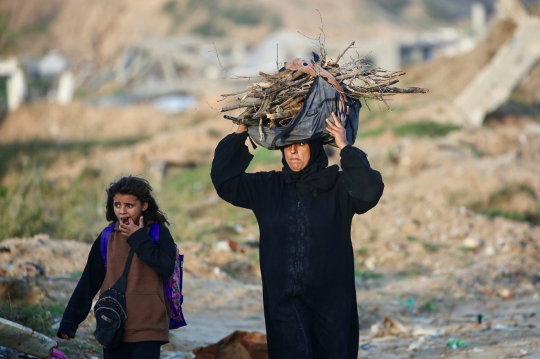 Une Palestinienne porte du bois dans le camp de Nousseirat, dans le centre de la bande de Gaza, le 31 décembre 2025