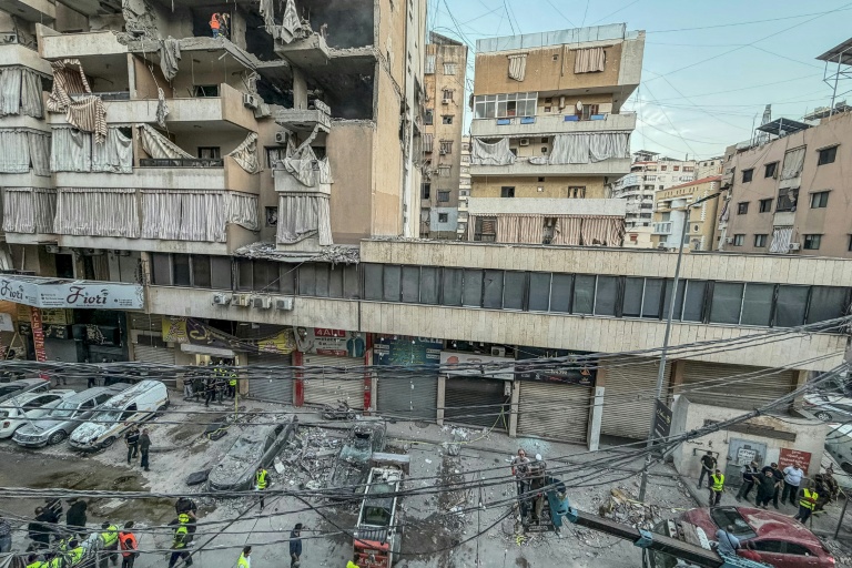 Des personnes ramassent des gravats sur le site d'une frappe israélienne dans la banlieue sud de Beyrouth le 23 novembre 2025.