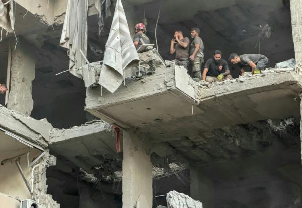 Des secouristes dans l'immeuble touché par une frappe d'Israël, qui a affirmé avoir visé le chef d'état major du Hezbollah, dans la banlieue sud de Beyrouth, le 23 novembre 2025 