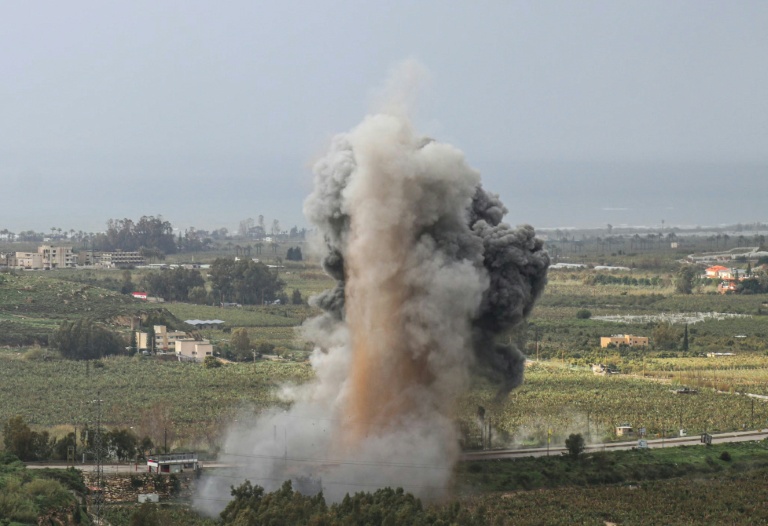 Un panache de fumée s'élève du site du pont de Qasmiyeh visé par une frappe israélienne, le 22 mars 2026 au sud du Liban