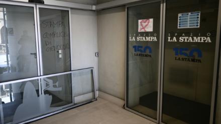 Un graffiti "La Stampa complice du génocide"  (g) devant les rédactions des journaux La Stampa et Repubblica lors d'une manifestation pour la libération de Mohamed Shahin, le 28 novembre 2025 à Turin 