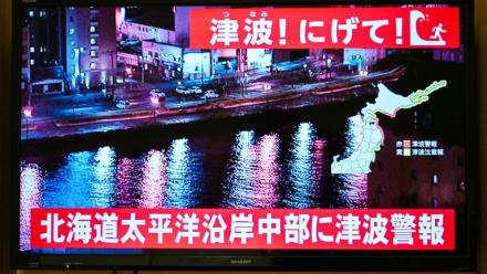 Un avertissement indiquant "Tsunami ! Courez !" (en haut) et "Alerte au tsunami émise pour la côte Pacifique du centre de Hokkaido" s'affiche sur un écran de télévision à Sapporo, au Japon, le 9 décembre 2025