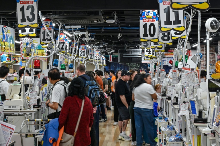 Des touristes aux caisses d'un magasin du détaillant discount japonais Don Quijote, dans le quartier de Shibuya à Tokyo, le 21 avril 2025