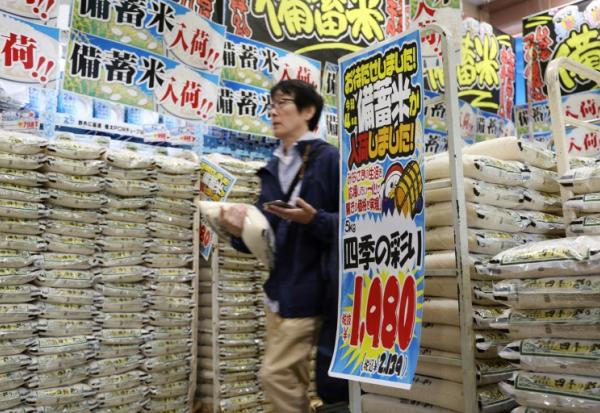 Un client passe devant des sacs de riz vendus par la chaîne de magasins discount Don Quijote à Tokyo, le 1er juin 2025