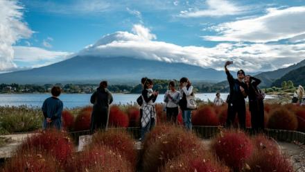 Des touristes prennent des photos devant le Mont Fuji, le 18 octobre 2025 à Fujikawaguchiko, au Japon