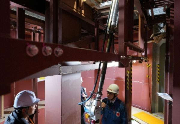 Un bras robotique effectue une démonstration d'enlèvement de débris de combustible nucléaire fondu lors d'une simulation à la centrale nucléaire de Fukushima Daiichi, exploitée par Tokyo Electric Power Company, le 25 février 2026 à Naraha, dans la préfecture de Fukushima, au Japon