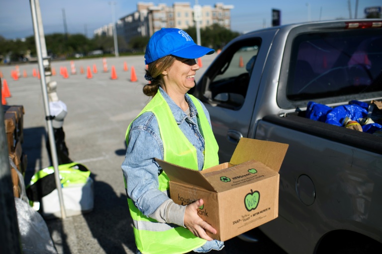 Une bénévole porte un carton lors d'une distribution d'aide alimentaire à Houston, au Texas, le 1er novembre 2025