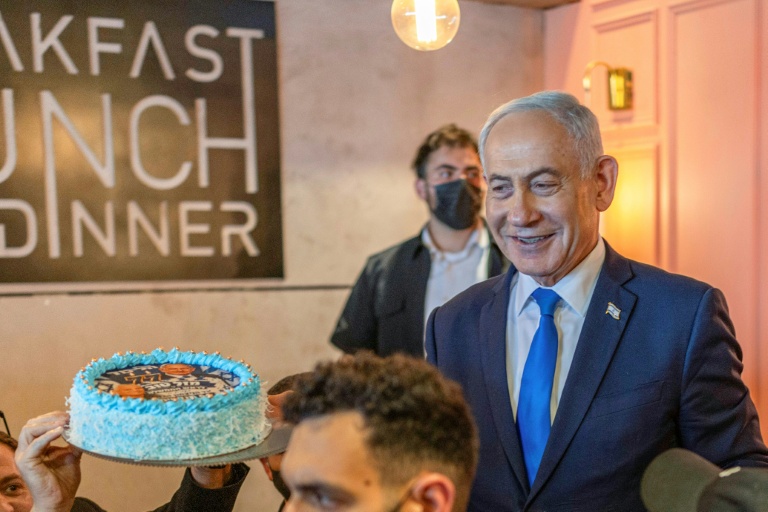 Le Premier ministre israélien Benjamin Netanyahu (d) échange avec des sympathisants venus lui offrir un gâteau pour son 77e anniversaire, lors d’une rencontre dans un café à Dimona, le 21 octobre 2026 en Israël