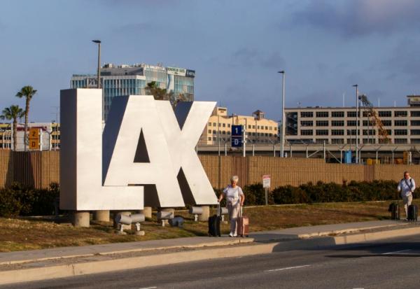 Des passagers avec leurs bagages près du Los Angeles International Airport (LAX), à Los Angeles, en Californie le 15 mai 2026