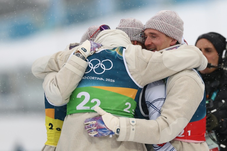 Les Français Eric Perrotis, Quentin Fillon Maillet, Emilien Jacquelin et Fabien Claude se congratulent après leur victoire dans le relais 4 x 7,5 km du biathlon des JO-2026 à Anterselva le 17 février 2026 en Italie 
