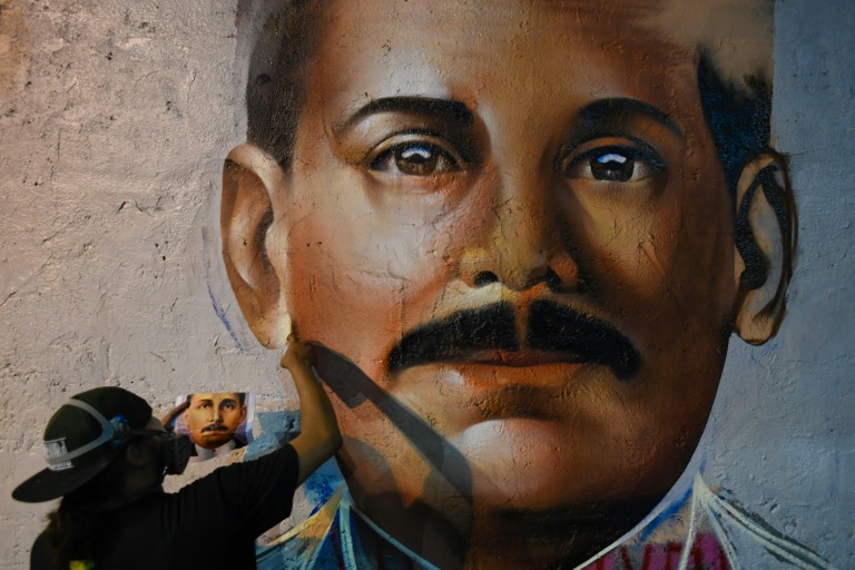 Le graffeur Wolfgang Salazar, alias Badsura, met la touche finale à un portrait du médecin vénézuélien Jose Gregorio Hernandez sur un mur de Caracas, le 27 avril 2021