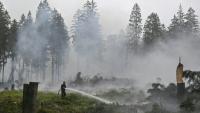 Un pompier arrose la végétation lors d'une intervention contre un feu de forêt dans la réserve naturelle des Hautes Fagnes, près de Baelen, le 18 août 2026 en Belgique