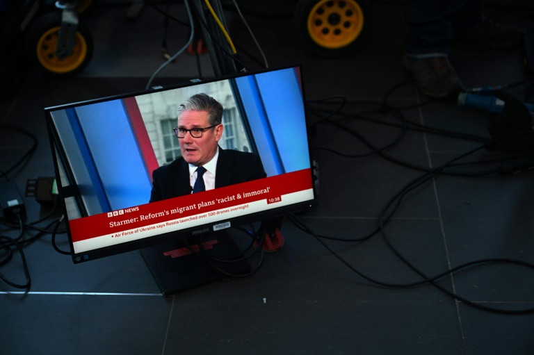 Un écran de télévision retransmet une interview de la BBC avec le Premier ministre britannique Keir Starmer et le titre 