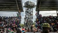 Des partisans de Raila Odinga sont montés sur un château d'eau près du stade où est exposée la dépouille de l'opposant, à Kisumu, dans l'ouest du Kenya, le 18 octobre  2025