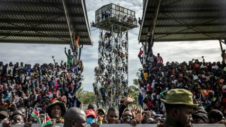 Des partisans de Raila Odinga sont montés sur un château d'eau près du stade où est exposée la dépouille de l'opposant, à Kisumu, dans l'ouest du Kenya, le 18 octobre  2025