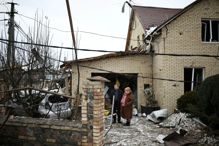 Des habitants constatent les dégâts après une attaque aérienne à Sofiivska Borshchagivka, dans la région de Kiev, le 22 février 2026