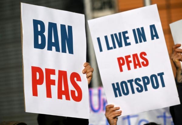 Des pancartes lors d'une manifestation contre les substances chimiques PFAS, près du siège de la Commission européenne à Bruxelles, le 5 mars 2026.