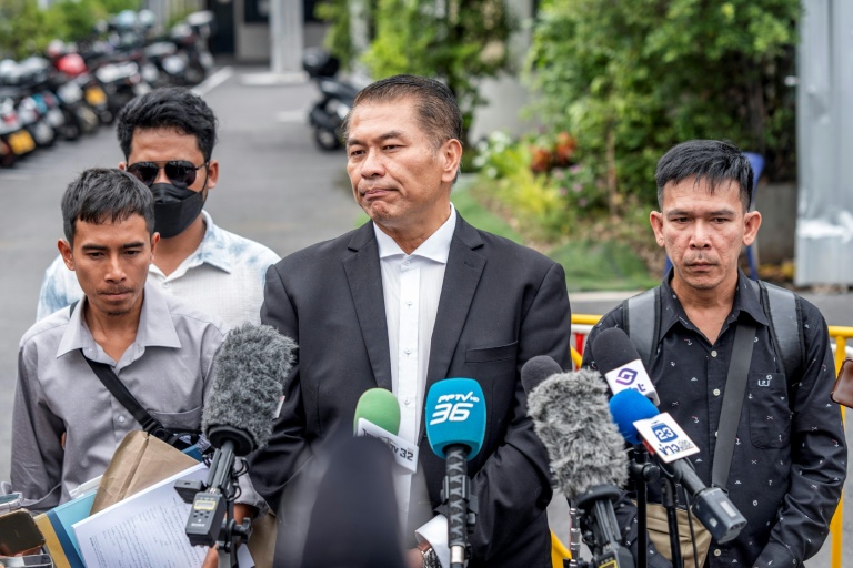 L'avocat Kunpat Singhathong (c) s'adresse aux médias aux côtés de trois anciens marins du cargo battant pavillon thaïlandais *Mayuree Naree*, devant le Tribunal central du travail à Bangkok, le 10 juillet 2026 en Thaïlande