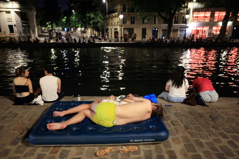 Une personne se rafraîchit au bord du canal Saint-Martin, à Paris, le 25 juin 2026