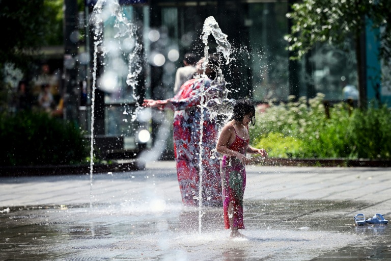 Une enfant se rafraîchit sous des jets d’eau à Bruxelles, lors d’une vague de chaleur, le 19 juin 2026