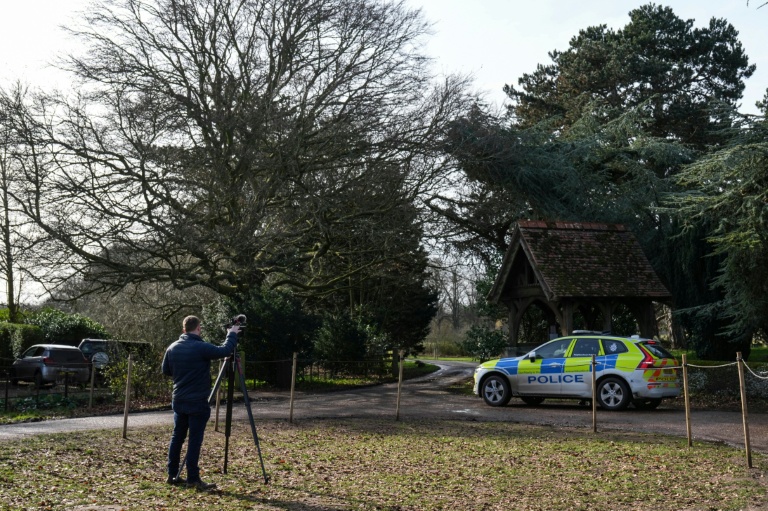 Un journaliste et un véhicule de police à l'entrée de Wood Farm, sur le domaine de Sandringham, appartenant à la famille royale britannique, en Angleterre, le 22 février 2026
