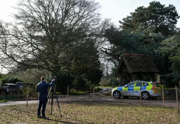 Un journaliste et un véhicule de police à l'entrée de Wood Farm, sur le domaine de Sandringham, appartenant à la famille royale britannique, en Angleterre, le 22 février 2026