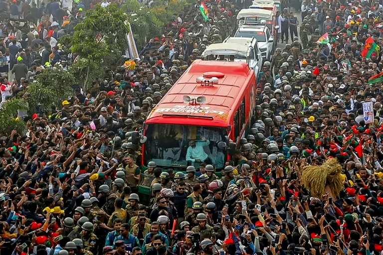 Photo prise et diffusée le 25 décembre 2025 par la cellule médias du Parti nationaliste du Bangladesh (BNP) sur sa page Facebook officielle, montrant le président par intérim du BNP, Tarique Rahman (c), saluant ses partisans depuis un bus à son arrivée à Dacca