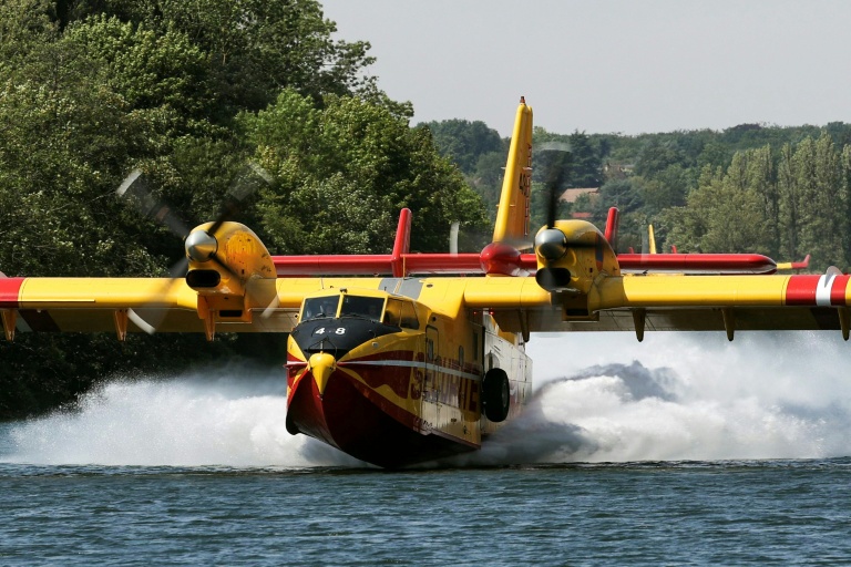 Un Canadair CL-415 de la Sécurité civile effectue des manœuvres d'écopage au-dessus de la Seine à Chartrettes, le 13 juillet 2026, pour lutter contre un incendie dans la forêt de Fontainebleau, en Seine-et-Marne