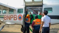 Des agents de l'Agence nationale de gestion des catastrophes chargent du chlorure de sodium dans un avion avant une opération d'ensemencement des nuages à Palangkaraya, dans le Kalimantan central, le 2 août 2026 en Indonésie