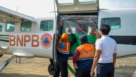 Des agents de l'Agence nationale de gestion des catastrophes chargent du chlorure de sodium dans un avion avant une opération d'ensemencement des nuages à Palangkaraya, dans le Kalimantan central, le 2 août 2026 en Indonésie