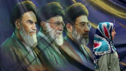 Une Iranienne passe devant les portraits des trois guides suprêmes iraniens depuis l'avènement de la République islamique, le 28 mai 2026 à Téhéran