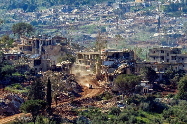 Un véhicule militaire israélien passe devant des maisons détruites par des frappes israéliennes dans le sud du Liban, vu depuis une position de l’autre côté de la frontière, en Haute Galilée, au nord d’Israël, le 7 mai 2026