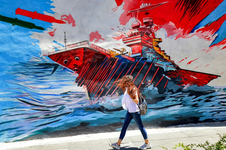 Une femme passe devant une peinture murale anti-américaine et anti-israélienne, le 26 mai 2026 à Téhéran