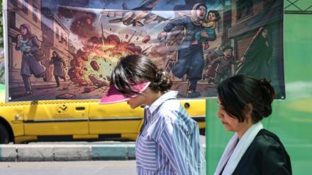 Une Iranienne passe devant une banderole représentant l'attaque américano-israélienne contre l'Iran, dans la capitale Téhéran, le 9 mai 2026