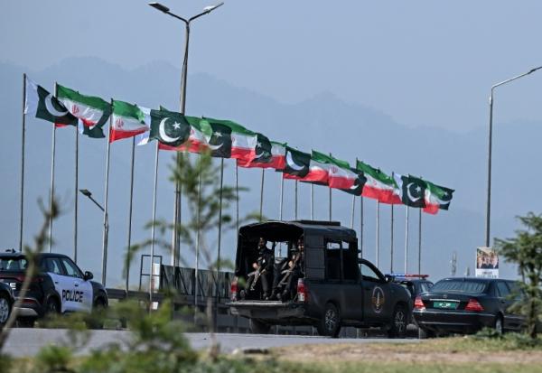 Des drapeaux iraniens et pakistanais le long de la route empruntée par le cortège du président iranien Massoud à son arrivée à Islamabad, le 23 juin 2026 au Pakistan