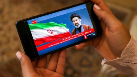Une femme consulte sur son mobile un message du guide suprême iranien Mojtaba Khamenei, le 26 mai 2026 à Téhéran