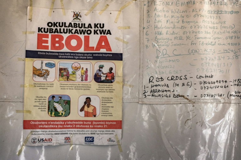 Une affiche d'information indique les numéros d'urgence liés à Ebola,dans une tente au poste-frontière de Busunga, entre l'Ouganda et la République démocratique du Congo, à Bundibugyo, le 18 mai 2026. 
