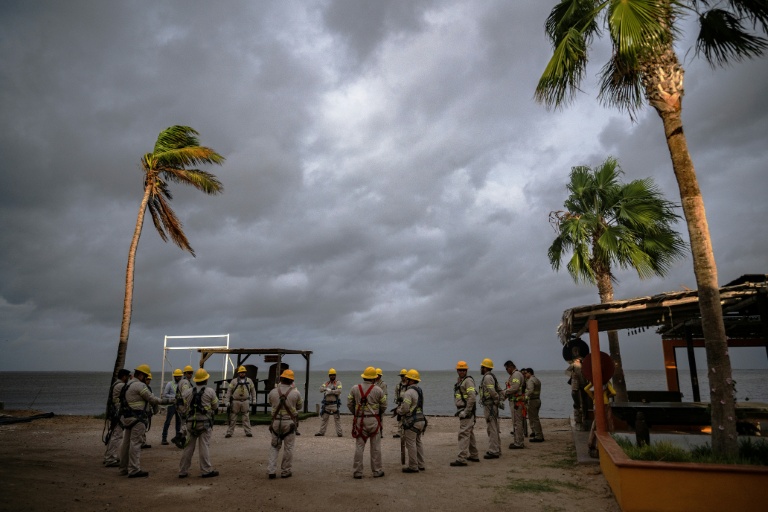 Des employés de la compagnie d'électricité réunis sur la plage de Puerto San Carlos, au Mexique, avant l'arrivée de l'ouragan Polo, le 28 septembre 2026